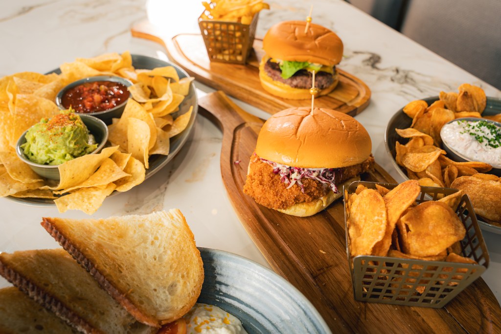 March 2026 new menu. Handhelds and dips spread on a marble counter.